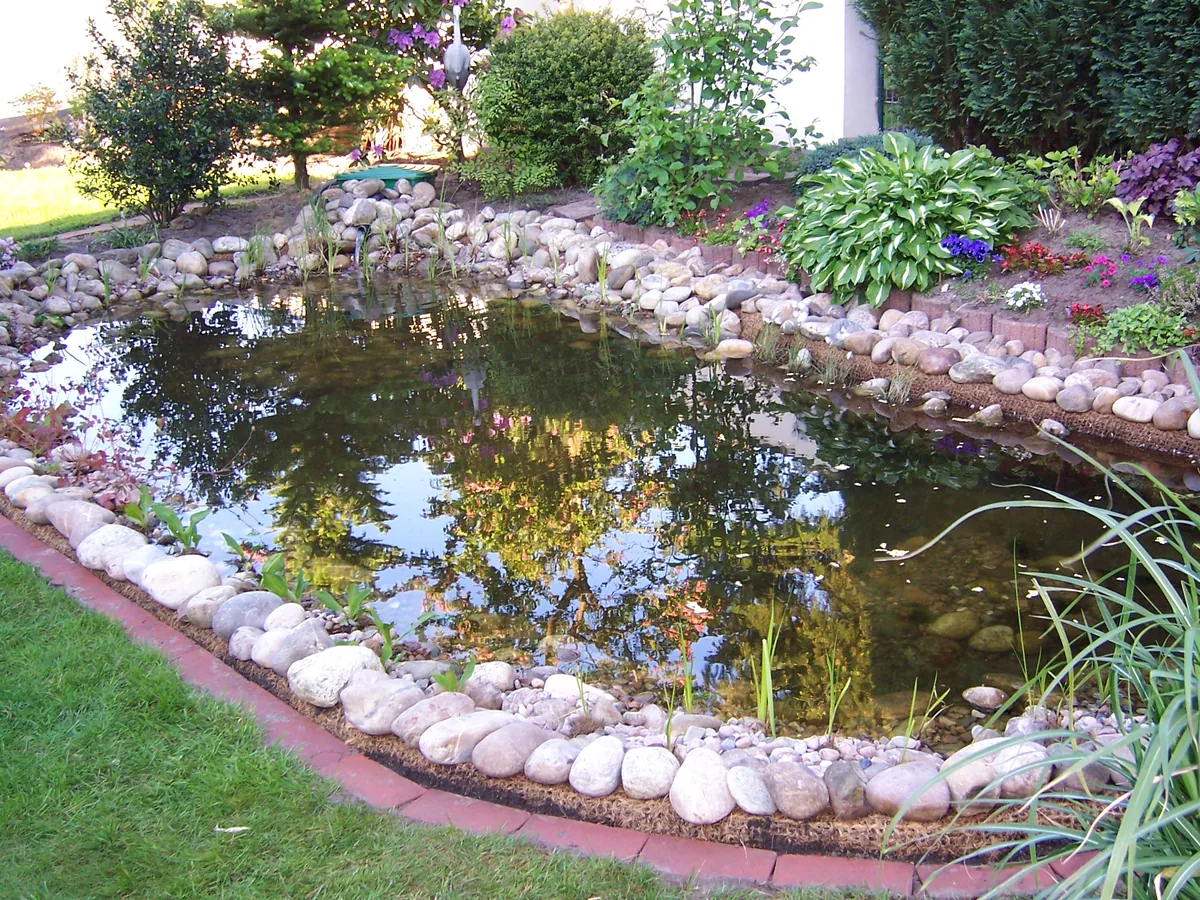 Fertiger Gartenteich mit Kieselrand und Stauden